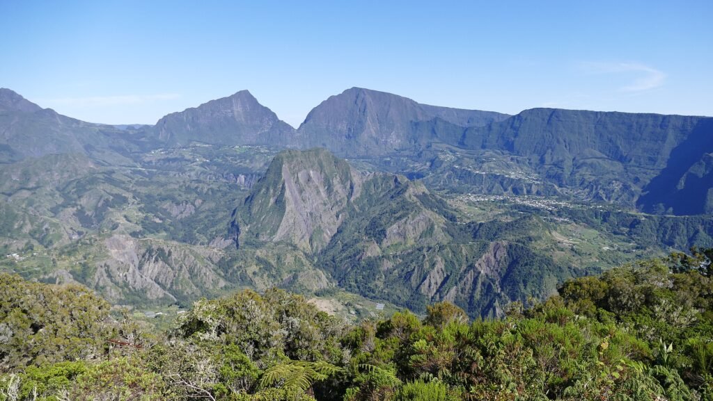 Green volcanic peaks and steep ridges of the Cirque de Salazie on La Réunion, seen from above under a clear blue sky