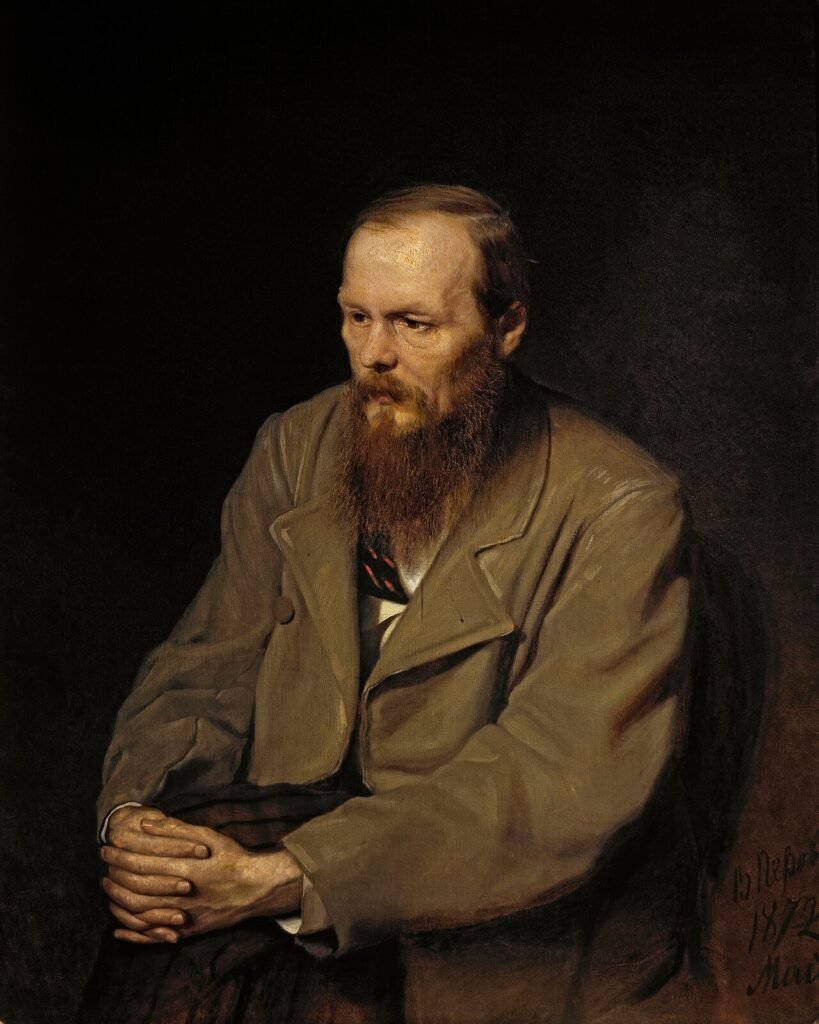 Oil portrait of Fyodor Dostoevsky, seated with his hands clasped over one knee, in a brown coat against a dark background