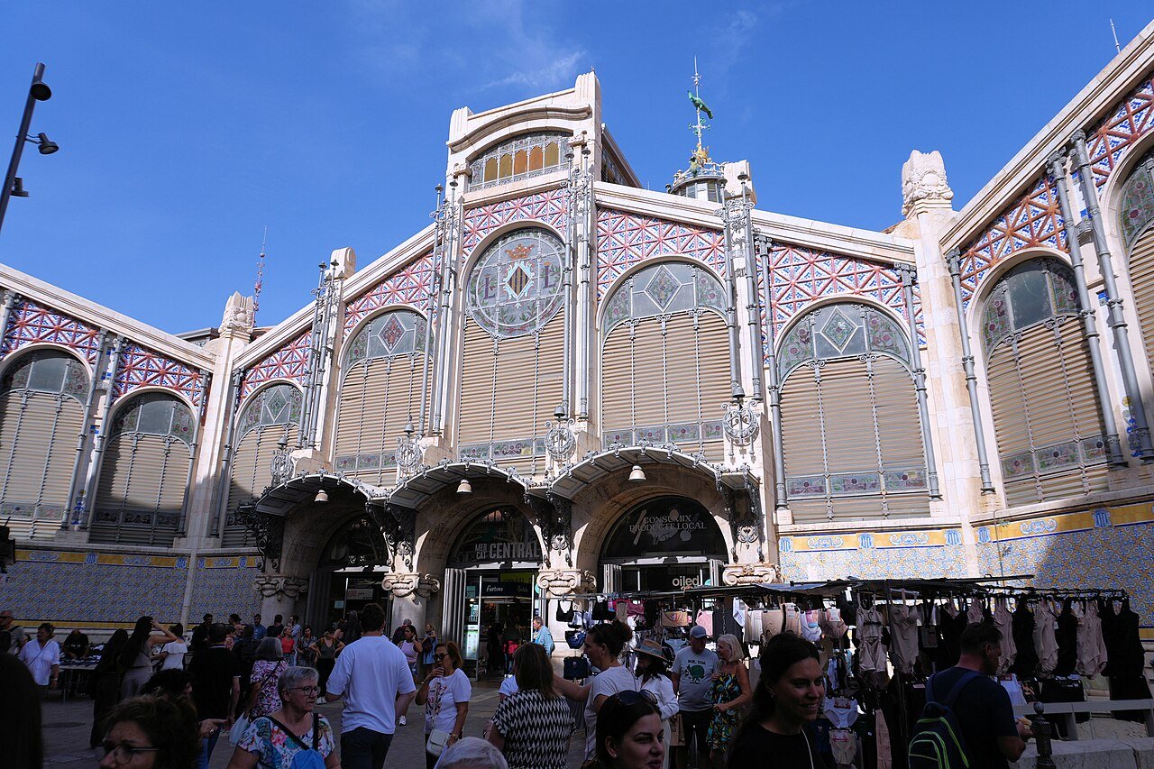 The front of the Mercat Central in Valencia, with its iron, glass and coloured tile façade and a crowd at the entrance