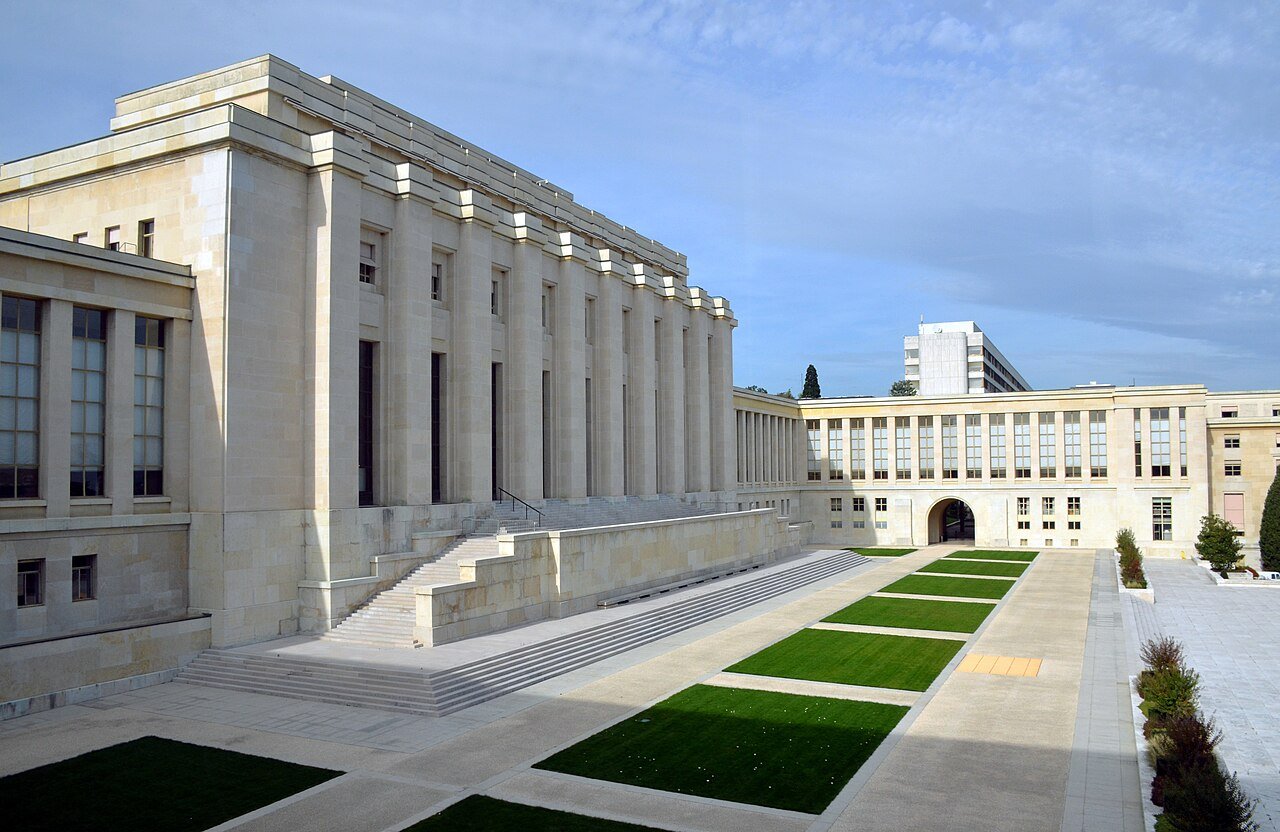 The pale stone Palais des Nations in Geneva, home of the United Nations Office at Geneva, with lawns in front