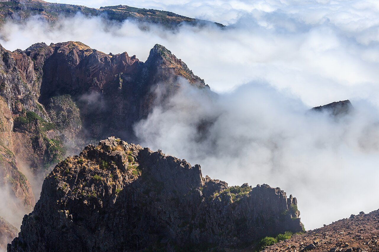 Clouds drifting between dark volcanic ridges seen from Pico do Areeiro, Madeira