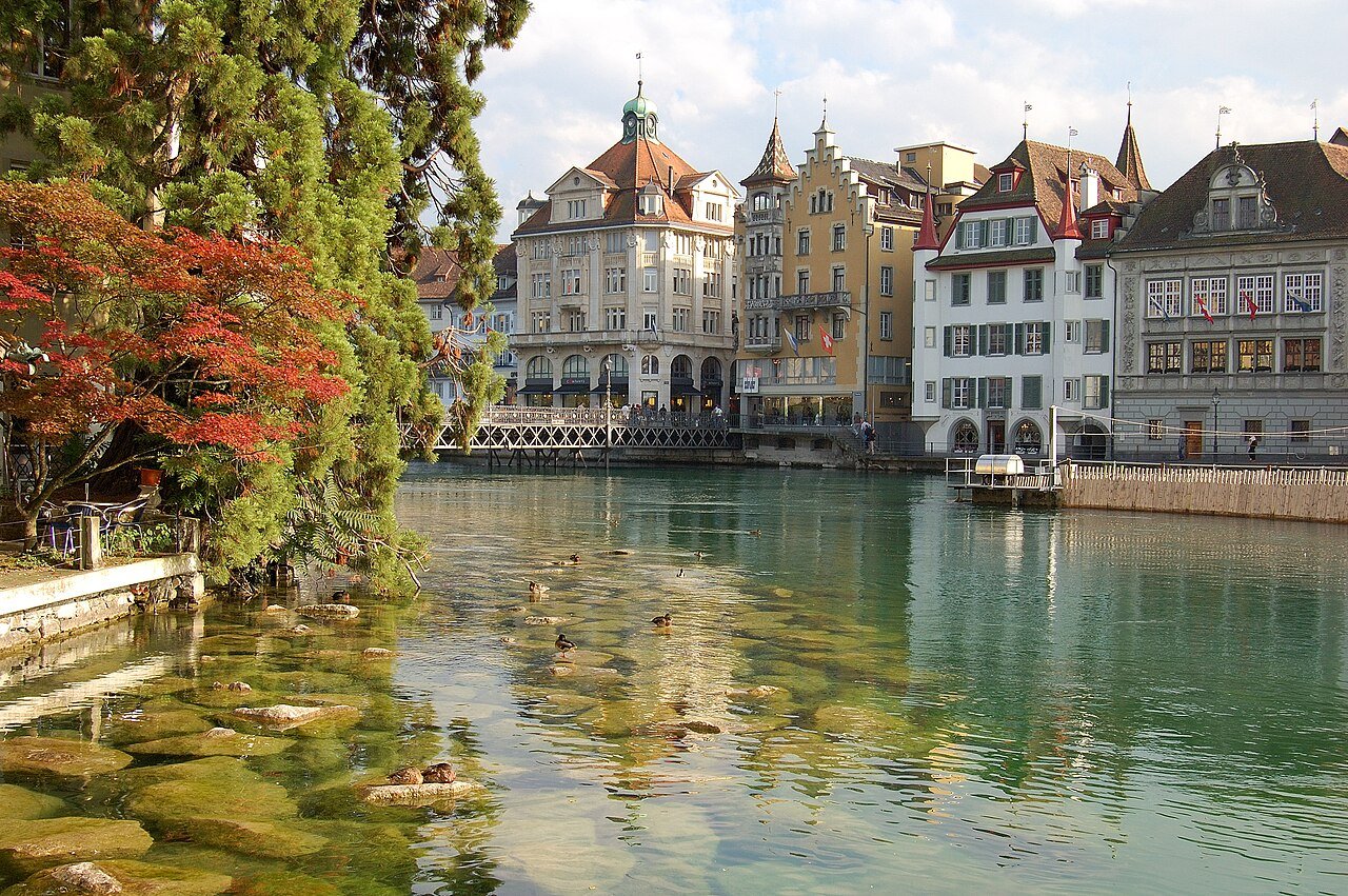 The clear green River Reuss flowing past painted old-town buildings in Lucerne