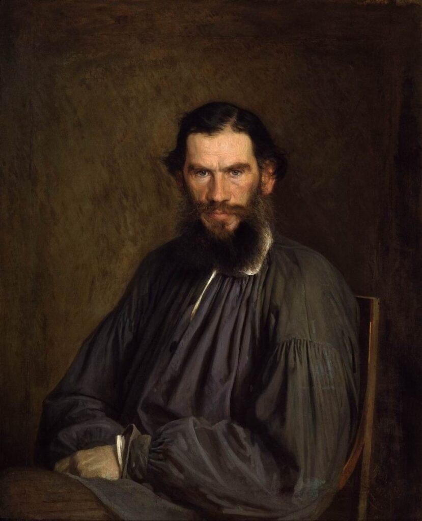 Oil portrait of Leo Tolstoy, bearded and seated in a dark smock, looking directly at the viewer